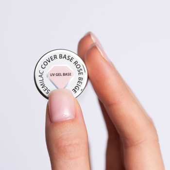 Zbliżenie: dłoń trzyma wieczko Semilac Cover Base Rose Beige UV Gel Base, srebrne z różowym rombem.