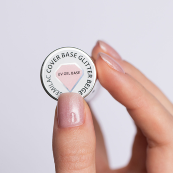 Dłoń trzyma okrągłą bazę Semilac Cover Base Glitter Beige; widok z góry na srebrne wieczko z nazwą produktu.