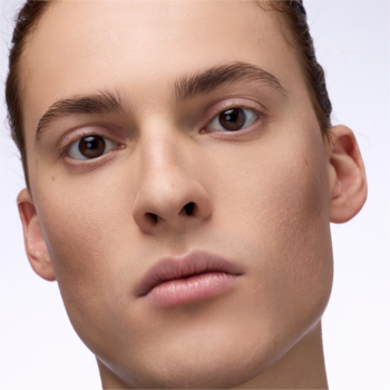 Twarz modela z rozświetlonym podkładem Catrice Soft Glam Filter. Jasna cera, zdrowy blask.