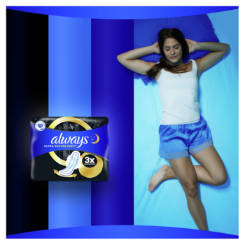Always Ultra Secure Night Extra (rozmiar 5) podpaski w czarnym opakowaniu, obok śpiącej kobiety w niebieskiej pościeli.