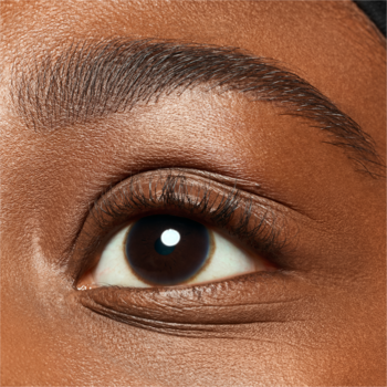 Zbliżenie na oko osoby z ciemną karnacją i zdefiniowaną brwią po użyciu Essence Brow Powder Duo Dark.
