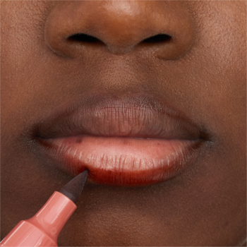 Zbliżenie na usta. Aplikacja brązowego Essence Line N' Stain Tatoo Lip Liner Must Have Brown do konturowania warg.