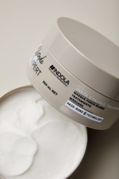 Maska Indola Blonde Expert Insta Strong do włosów blond, otwarty słoik, widok z góry. Biały krem, Hair-Bond Technology.