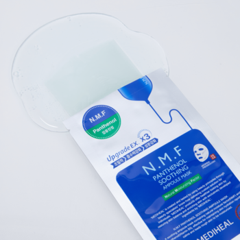 Otwarta koreańska maska Mediheal N.M.F Panthenol Soothing Ampoule w płachcie, z wylanym, przejrzystym serum.