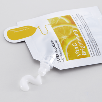 Biała saszetka Mediheal Vita C Brightening Sleeping Mask, z której wyciskany jest biały, rozświetlający krem.