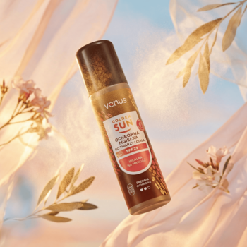 Venus Golden Sun spray ochronny SPF 25 do twarzy i ciała, brązowa butelka unosi się na tle różowych tkanin.