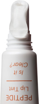Biała tubka peptydowego balsamu do ust Is It Clear? z białym aplikatorem, widok z góry na brązowe napisy.