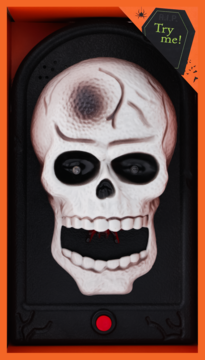 Dzwonek Halloween w formie białej czaszki z pająkiem na ustach, widoczny w otwartym, pomarańczowym pudełku.