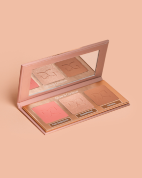 Luksusowa paleta Dessi Glow & Contour. Otwarta kasetka z różem, rozświetlaczem i bronzerem, widok pod kątem, na beżowym tle.