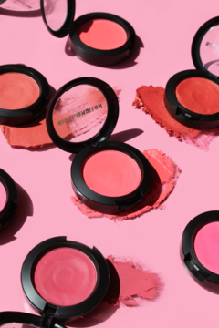Rozsypane J.Cat Beauty Blush Mallow Soft Blusher w otwartych puderniczkach, różowe i koralowe odcienie na różowym tle.