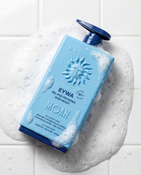 Niebieski odżywczy żel pod prysznic MOAN z pompką, leży w pianie na kafelkach, widok z góry.