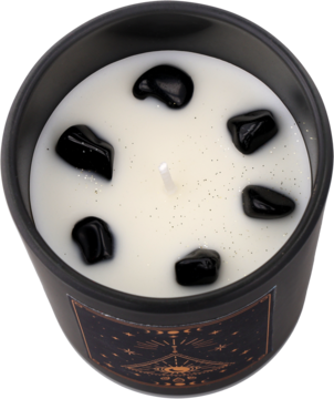 Czarna świeca z białym woskiem, sześcioma czarnymi kamieniami i złotą mistyczną etykietą, widok z góry.