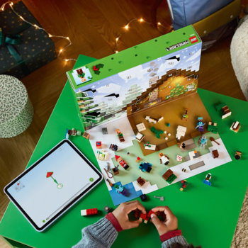 Dziecko bawi się otwartym kalendarzem adwentowym LEGO Minecraft z zimową wioską, figurkami i klockami na zielonym stole.