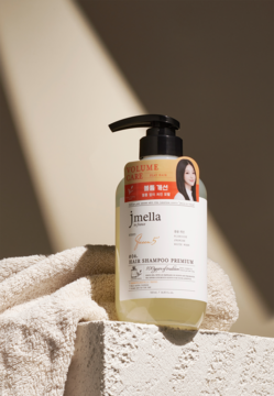 Jmella No.04 Queen 5 perfumowany szampon dla włosów cienkich, przezroczysta butelka z czarną pompką, na bloku.