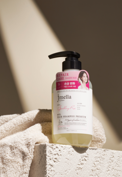 Jmella Sparkling Rose Premium, szampon regenerujący do włosów zniszczonych, butelka z pompką na bloku, widok z przodu.