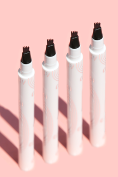 Cztery białe pisaki do brwi J.Cat Beauty Espresso z różowym wzorem i końcówką 4 ząbkami, na różowym tle.