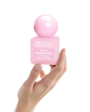 Ręka trzyma różowy płyn micelarny Bielenda Skin Perfection Quick Makeup Remover, butelka z kulistą nakrętką.