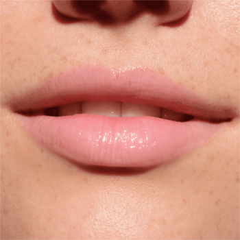 Usta z błyszczykiem Catrice Melt & Plump Juicy Lip Plumper 010 More Amore, pełne, błyszczące, różowe.