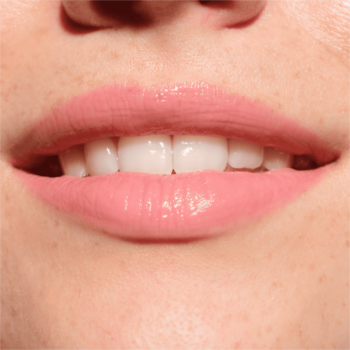 Zbliżenie na usta z błyszczykiem Catrice Melt & Plump Juicy Lip Plumper 020 Hyp-nude-tized, różowy nude, lśniące i pełne.