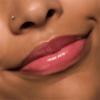 Zbliżenie na usta z błyszczykiem Essence Extreme Shine Volume Lipgloss 13 Glazed Berry, malinowy odcień, mokre wykończenie.