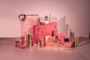Kalendarz adwentowy Sence Collection z różowymi i złotymi kosmetykami do makijażu, ułożony na różowym blacie.