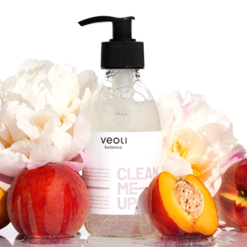 Przejrzysta butelka Veoli Botanica Clean Me Up, oczyszczający żel do mycia twarzy, z brzoskwiniami i białymi kwiatami.