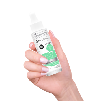 Bielenda Skin Clinic Centella Asiatica serum do twarzy w białej butelce z pipetą, w dłoni, widok z przodu.