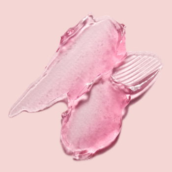 Zbliżenie na dwie przezroczyste, różowe smugi kremu-żelu MEDICUBE Collagen Jelly z kolagenem na różowym tle.
