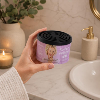 Ręka trzyma czarny odświeżacz Dorota & Aroma Home Konfitura malinowa, widok z przodu w łazience.