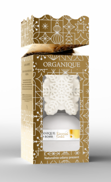 Organique Bubble Bomb w kształcie białej śnieżynki w złotym pudełku ze świątecznymi wzorami, widok z przodu.