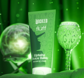 Zielona tuba balsamu Elphaba Detox Balm WICKED fluff, z sylwetką wiedźmy, widok z przodu, na magicznym zielonym tle z elementami fantastycznymi.