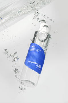 Tonik Isntree Hyaluronic Acid w przezroczystej butelce z niebieską etykietą, z wodnymi bąbelkami, nawilżający skórę.