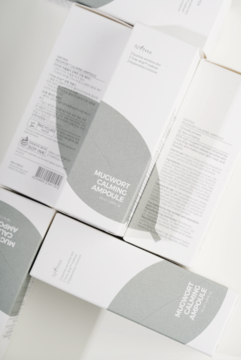 Isntree Mugwort Calming Ampoule: wiele białych opakowań z zielonym liściem, widok z góry, widoczne etykiety produktu.