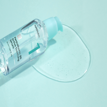 Numbuzin No.1 Pantothenic B5 Soothing Serum, butelka leżąca na turkusowym tle, obok kałuża serum.