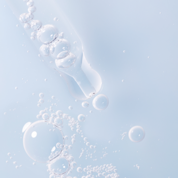 Lumene Nordic Hydra: krople nawilżającego serum z bąbelkami spływają z pipety na jasnoniebieskie tło.