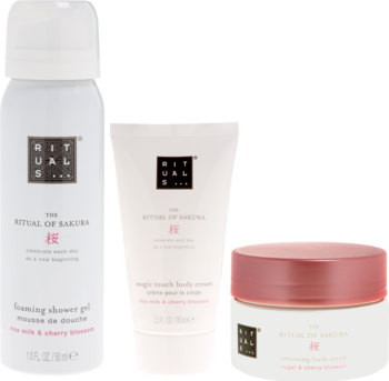 Zestaw Rituals The Ritual of Sakura z białym żelem pod prysznic, kremem i peelingiem. Widok pod kątem na trzy produkty.
