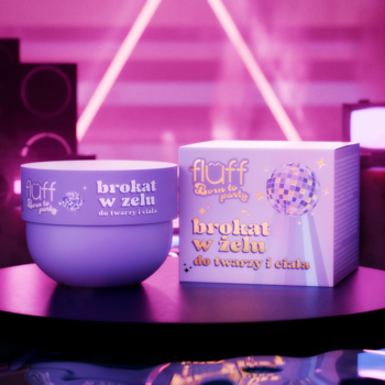 Fioletowy brokat w żelu Fluff Born To Party do twarzy i ciała, obok pasujące pudełko, na rozmytym tle świateł.