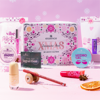 Essence DIY Xmas Treasure Box, adwentowy zestaw 24 kosmetyków do makijażu i pielęgnacji, na różowym tle z płatkami śniegu.