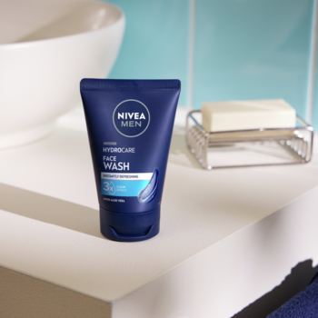 Niebieska tubka NIVEA MEN Hydro Care żel do mycia twarzy z aloesem i B5, na białym blacie łazienki.