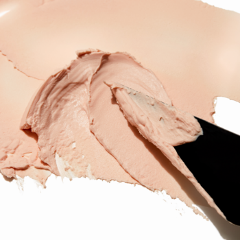 e.l.f. Poreless Putty Primer, kremowa baza wygładzająca pory, rozprowadzana szpatułką na białym tle.