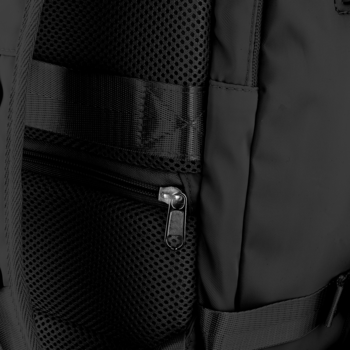 Zbliżenie na tylny panel czarnego plecaka: widoczna oddychająca siatka i pionowa kieszeń na zamek z suwakiem.