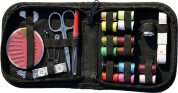 Otwarty czarny mini zestaw krawiecki z czerwonymi nożyczkami, igłami i kolorowymi nićmi, widok z góry.
