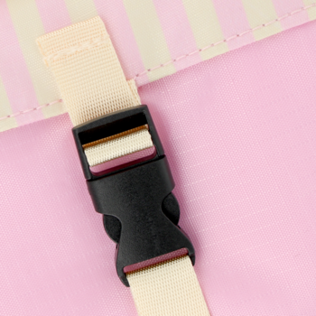 Eloy mini mata piknikowa: Detal czarnej plastikowej klamry z beżowym paskiem, na różowo-kremowej macie.