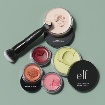 Czarny dwustronny pędzel e.l.f. do Putty Primer, z łopatką zanurzoną w jasnoróżowym kremie, otoczony kremowymi produktami w słoiczkach.