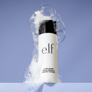 Biała butelka elf Clean Queen, pieniący żel do czyszczenia pędzli i gąbek, otoczona pianą na błękitnym tle.
