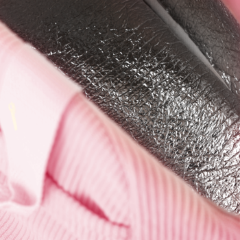 Eloy Lunchbox: Zbliżenie. Ciemny, błyszczący materiał z wyraźną fakturą obok miękkiej, różowej tkaniny.