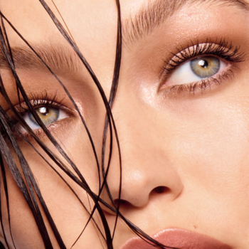 Zbliżenie na twarz kobiety, prezentujące oczy z długimi, uniesionymi rzęsami po użyciu tuszu Maybelline Lash Sensational Body.