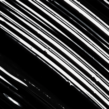 L'Oréal Paris Extentionist, zbliżenie na czarne, błyszczące smugi tuszu, ułożone ukośnie na białym tle.