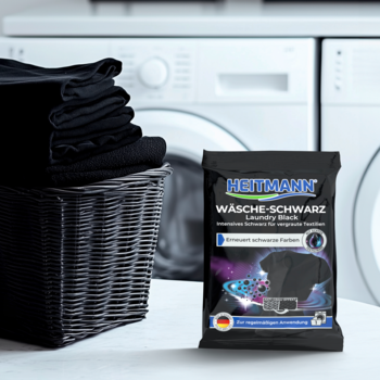 Heitmann Wäsche-Schwarz, saszetka do odświeżania czarnych tkanin, z czarnym praniem i pralką w tle.