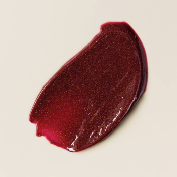 Rozmazana próbka błyszczącego balsamu peptydowego Say Hi Glassy Lips Berry, kremowa, na beżowym tle.